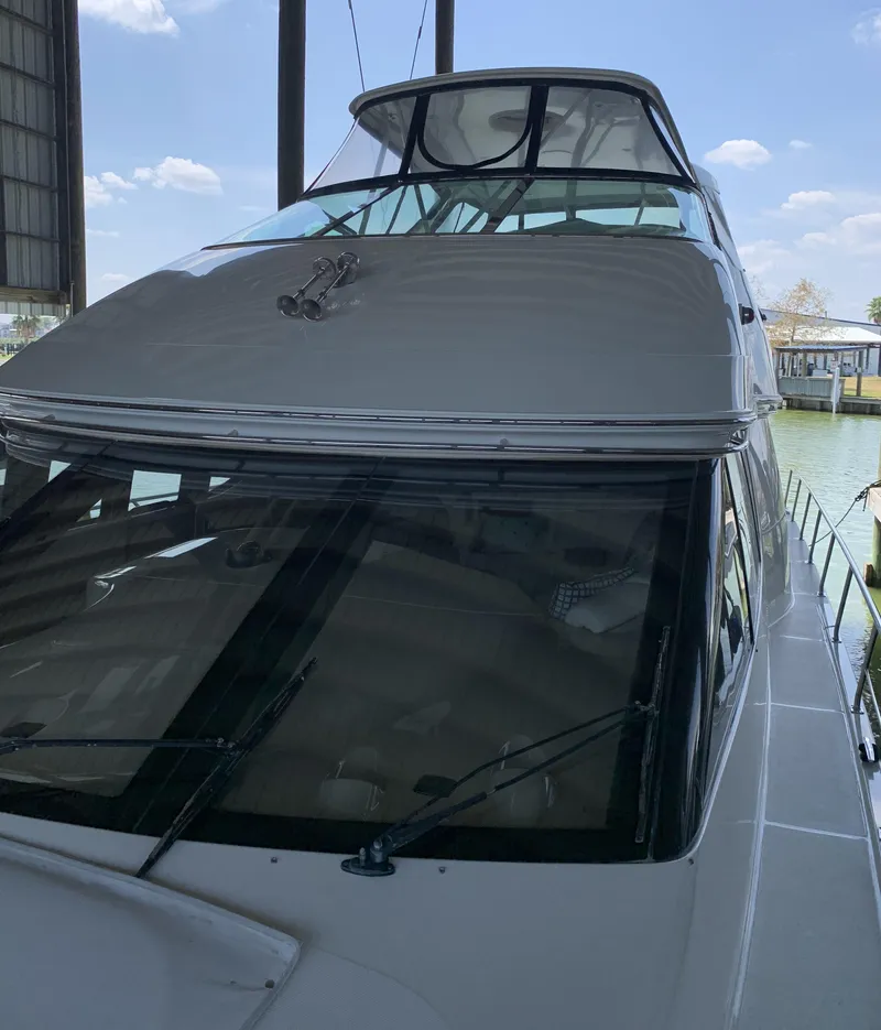 Slide: The Image of 2007 Carver 56 Voyager yacht docked under a canopy with clear skies. - 17