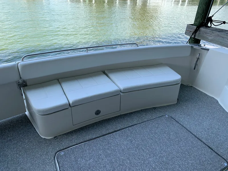 Slide: The Image of 2007 Carver 56 Voyager boat seating area with storage, overlooking calm water. - 22
