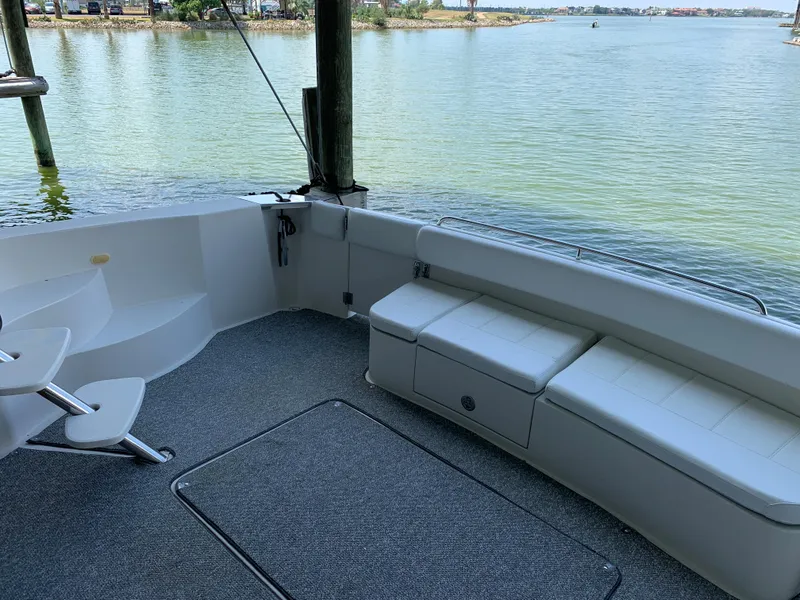 Slide: The Image of 2007 Carver 56 Voyager yacht deck with seating, overlooking serene water. - 23