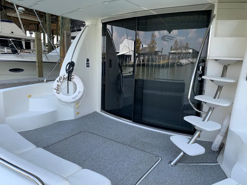 Slide: The Image of 2007 Carver 56 Voyager yacht deck with spiral staircase and marina view. - 25