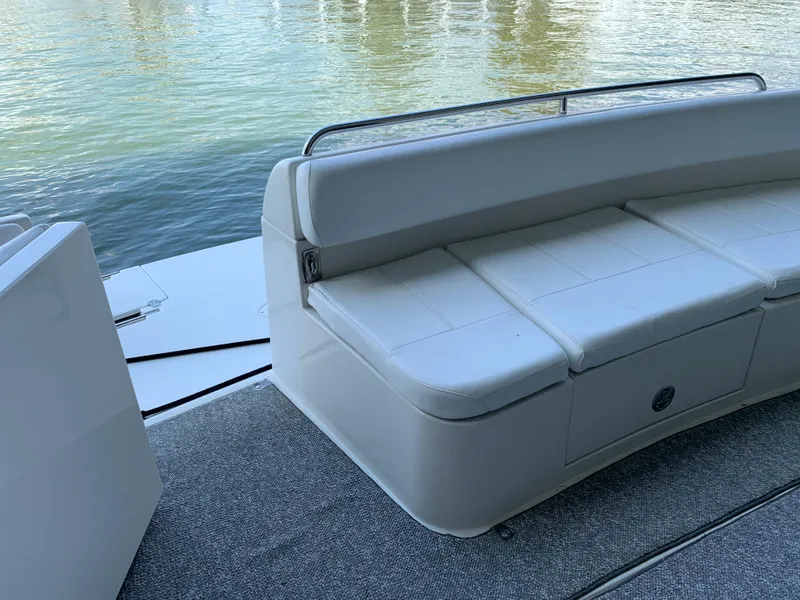 Slide: The Image of 2007 Carver 56 Voyager yacht seating area with white cushioned bench by the water. - 30