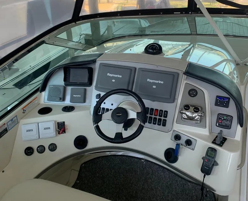 Slide: The Image of 2007 Carver 56 Voyager helm with Raymarine navigation, steering wheel, and control panels. - 33