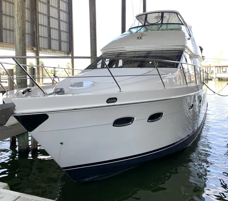 Slide: The Image of 2007 Carver 56 Voyager yacht docked in a marina, showcasing sleek design and luxury features. - 5