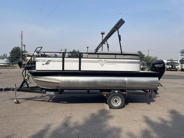 Slide: The Image of 2022 Viaggio DM16F pontoon boat on a trailer in a parking lot. - 0