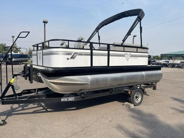 Slide: The Image of 2022 Viaggio DM16F pontoon boat on a trailer in a parking lot. - 1
