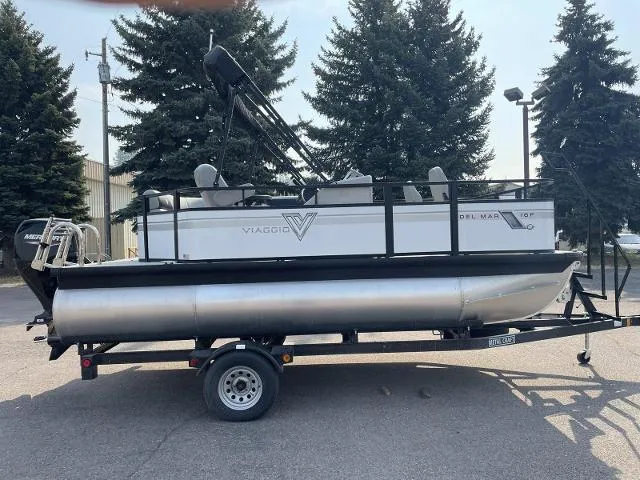Slide: The Image of 2022 Viaggio DM16F pontoon boat on a trailer, parked outdoors. - 7