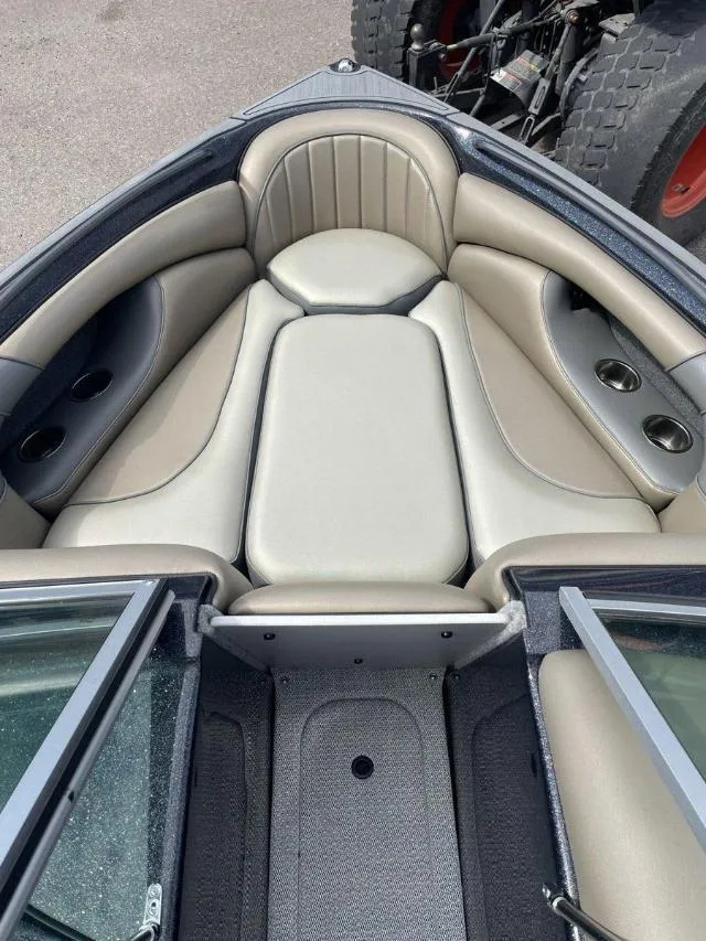 Slide: The Image of 2023 Sanger V-215 SX boat interior with cushioned seating and cup holders. - 11