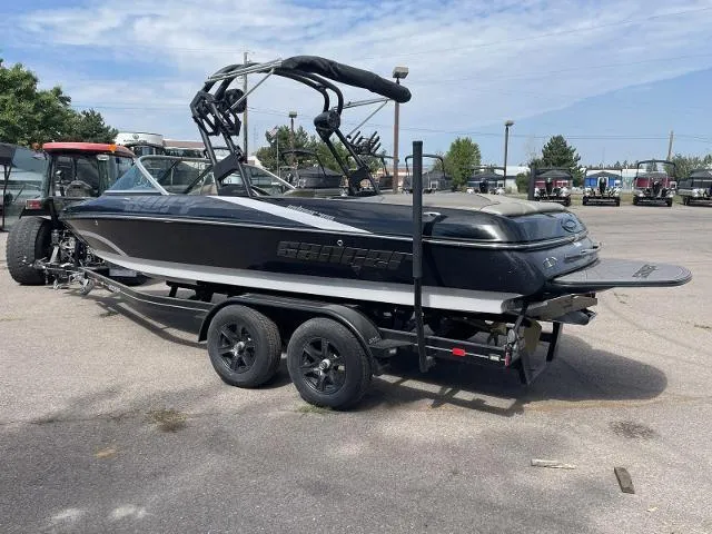 Slide: The Image of 2023 Sanger V-215 SX boat on a trailer in a parking lot. - 4