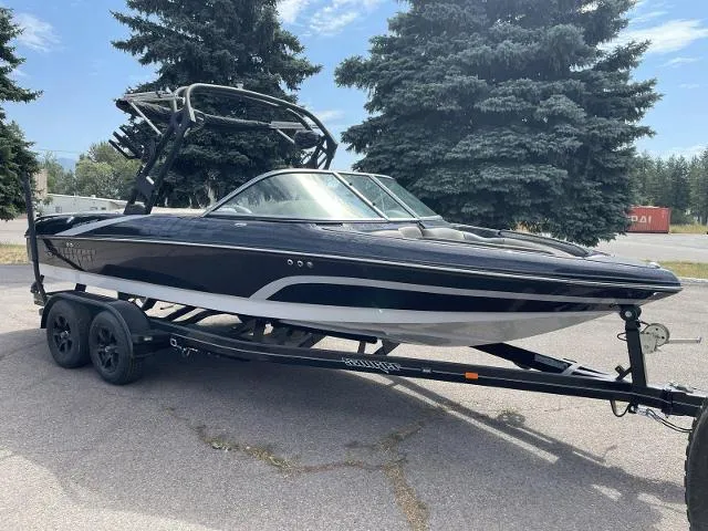 Slide: The Image of 2023 Sanger V-215 SX boat on a trailer, black and white, parked outdoors. - 2