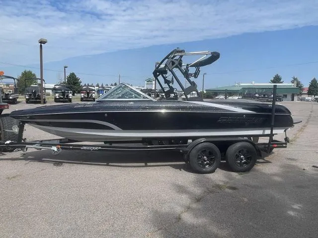 Slide: The Image of 2023 Sanger V-215 SX boat on a trailer, black and white exterior. - 3