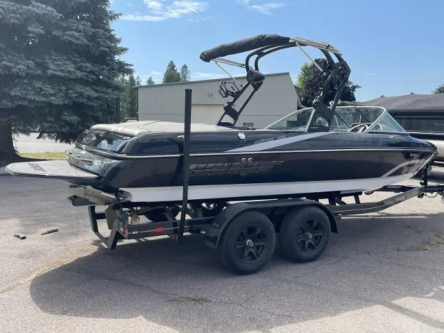 Slide: The Image of 2023 Sanger V-215 SX boat on a trailer, black and white exterior. - 5