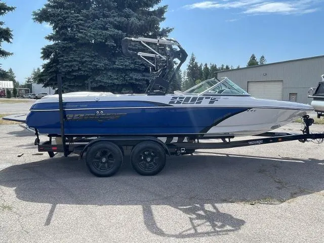 The Image of 2023 Sanger V215 SX boat on trailer, blue and white, parked outdoors. - 0