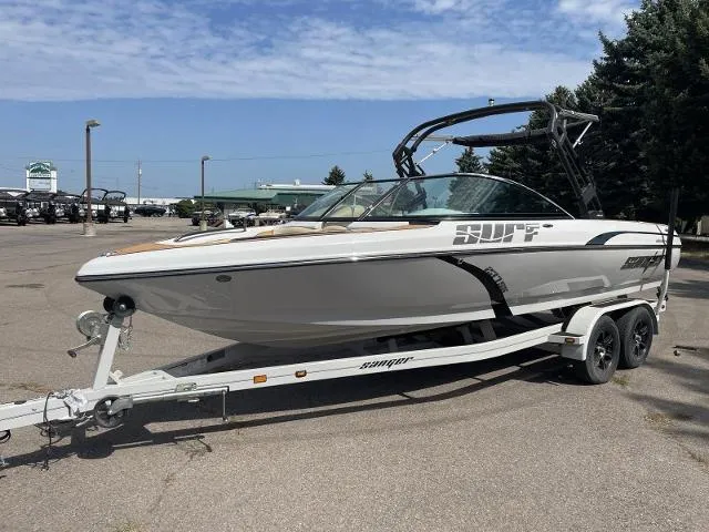 Slide: The Image of 2023 Sanger V237 SX boat on a trailer in a parking lot. - 2