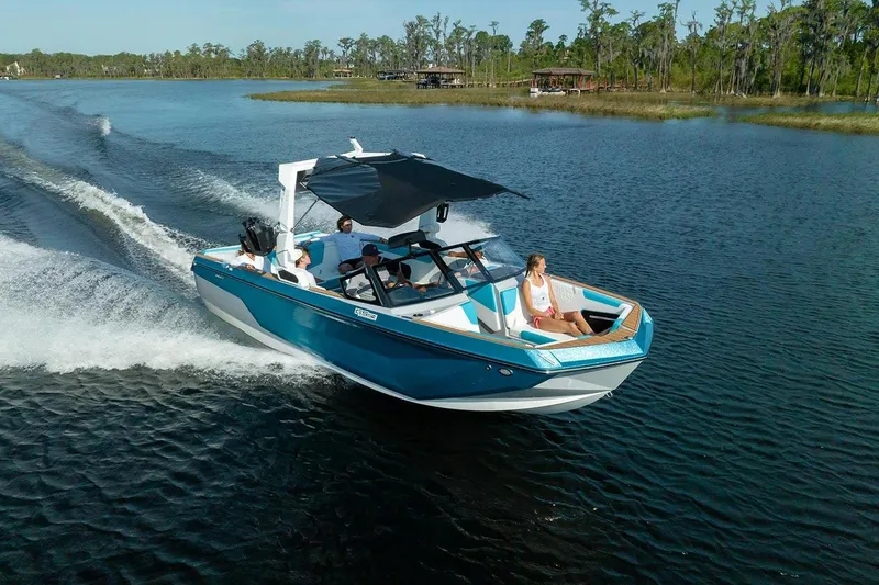 Slide: The Image of 2024 Nautique GS24 boat cruising on a lake with passengers. - 11