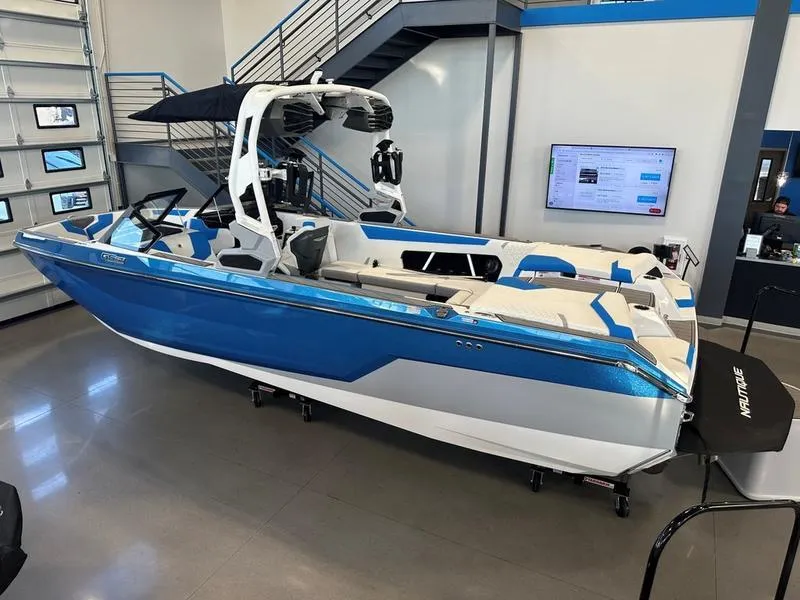 Slide: The Image of 2024 Nautique GS24 boat in showroom, blue and white exterior, modern design. - 3