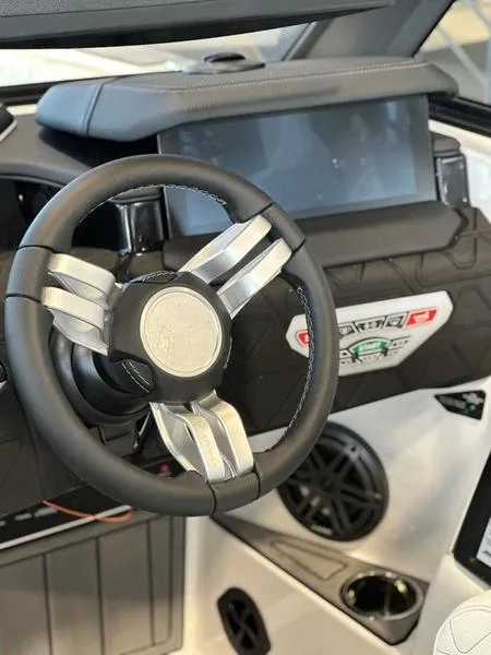 Slide: The Image of 2024 Nautique GS24 boat steering wheel and dashboard controls. - 5