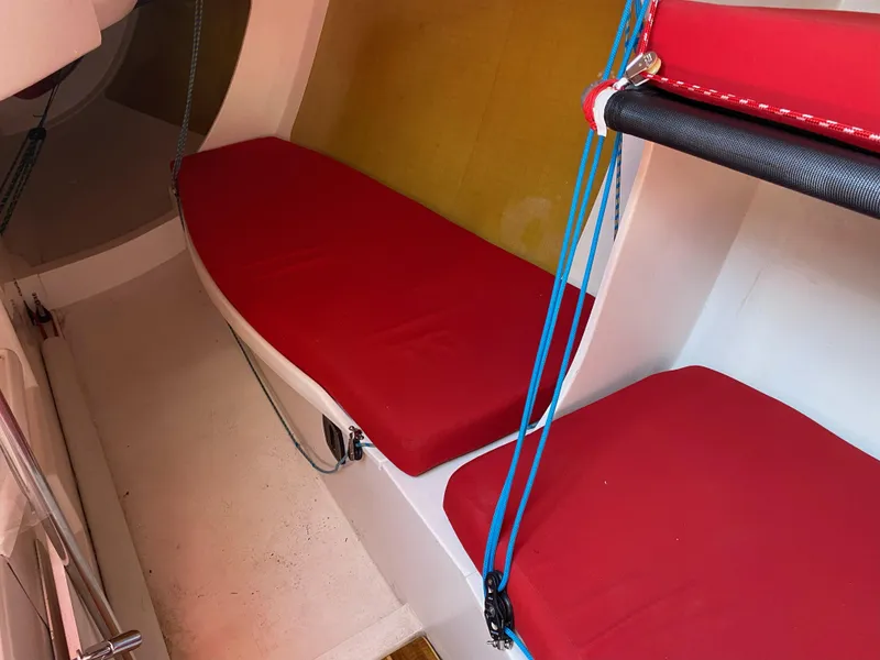 Slide: The Image of Interior of 2004 Farr 40 sailboat with red cushions and blue ropes. - 26