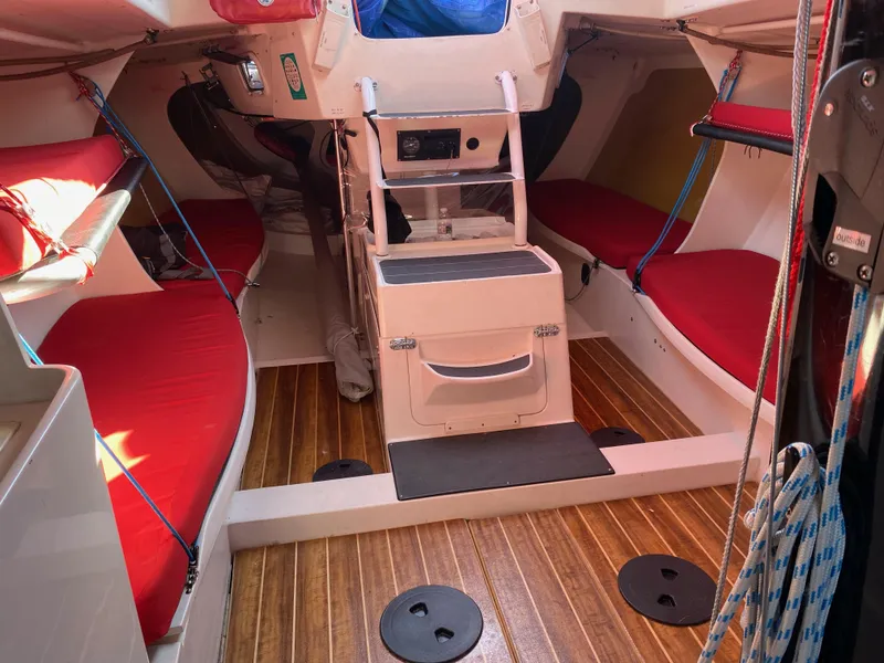 Slide: The Image of Interior of 2004 Farr 40 sailboat with red cushions and wooden flooring. - 30
