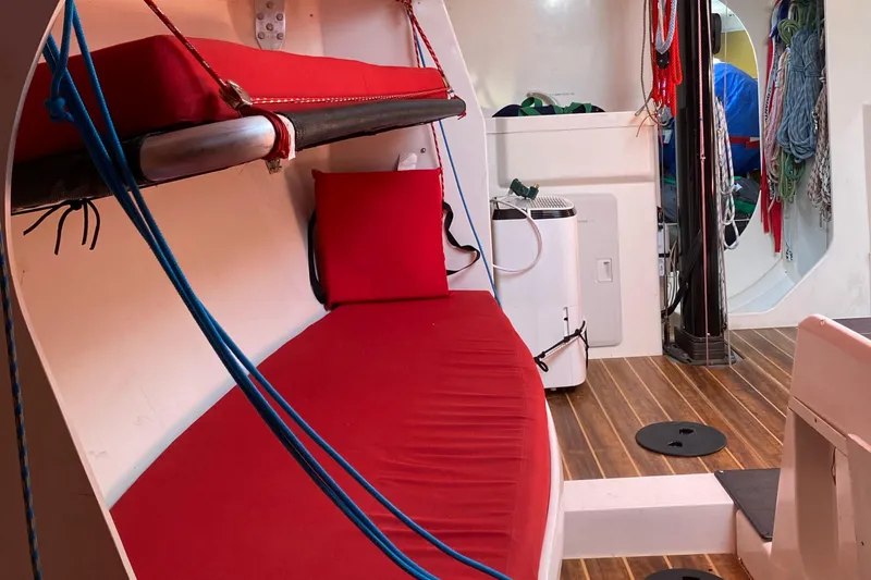 Slide: The Image of Interior of 2004 Farr 40 sailboat with red seating and wooden flooring. - 36