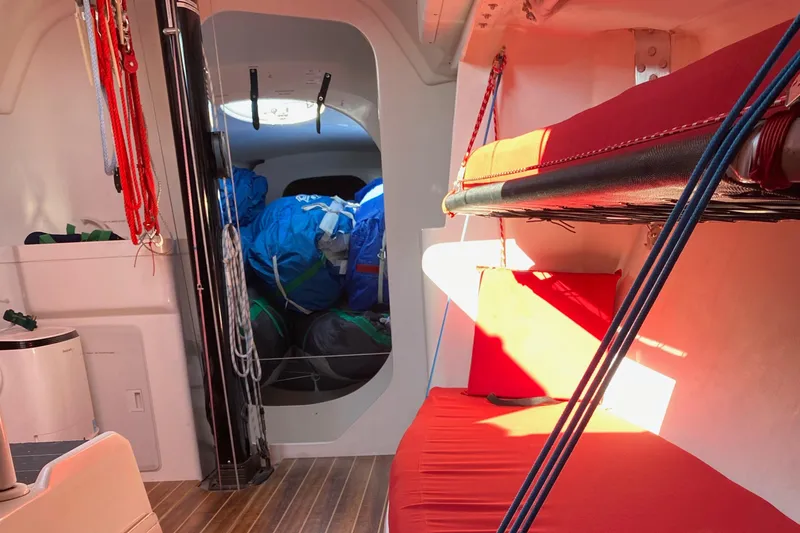 Slide: The Image of Interior of a 2004 Farr 40 sailboat with red bunks and sailing gear. - 37
