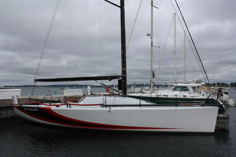 Slide: The Image of 2004 Farr 40 sailboat docked, featuring sleek design and red accents. - 5