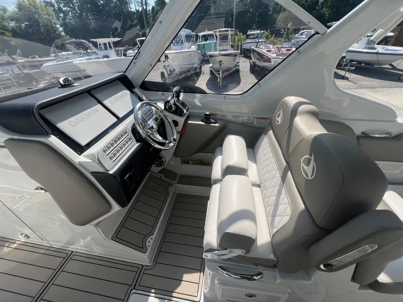 Slide: The Image of 2023 Finseeker 280 DC boat interior with Garmin displays and plush seating. - 12