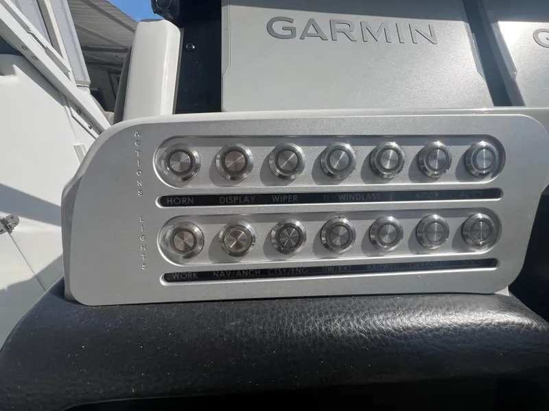 Slide: The Image of Control panel of 2023 Finseeker 280 DC boat with labeled buttons and Garmin equipment. - 16