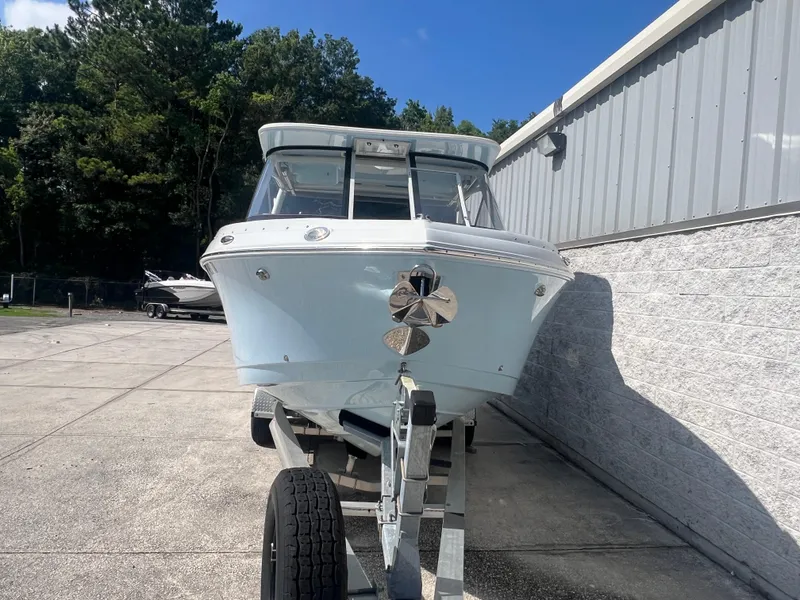 Slide: The Image of 2023 Finseeker 280 DC boat on trailer, parked outdoors near a building. - 2