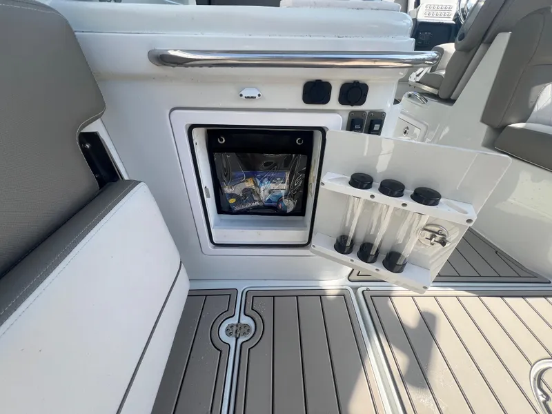 Slide: The Image of 2023 Finseeker 280 DC boat interior with storage compartment and rod holders. - 21