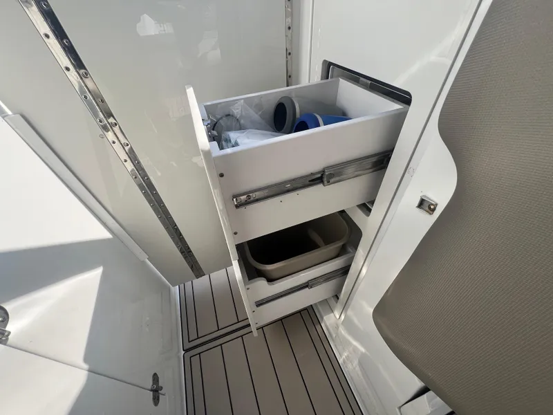 Slide: The Image of 2023 Finseeker 280 DC boat interior with open storage drawers and compartments. - 23