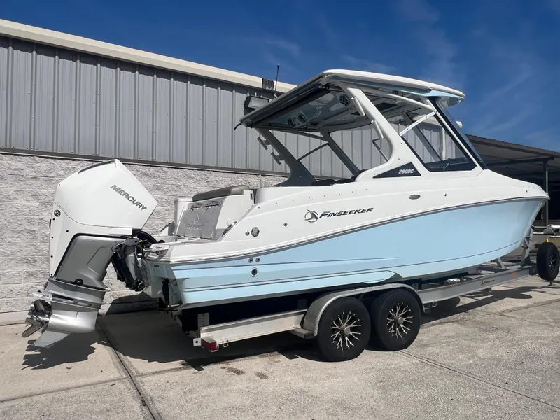 Slide: The Image of 2023 Finseeker 280 DC boat on trailer, featuring Mercury outboard engine. - 3