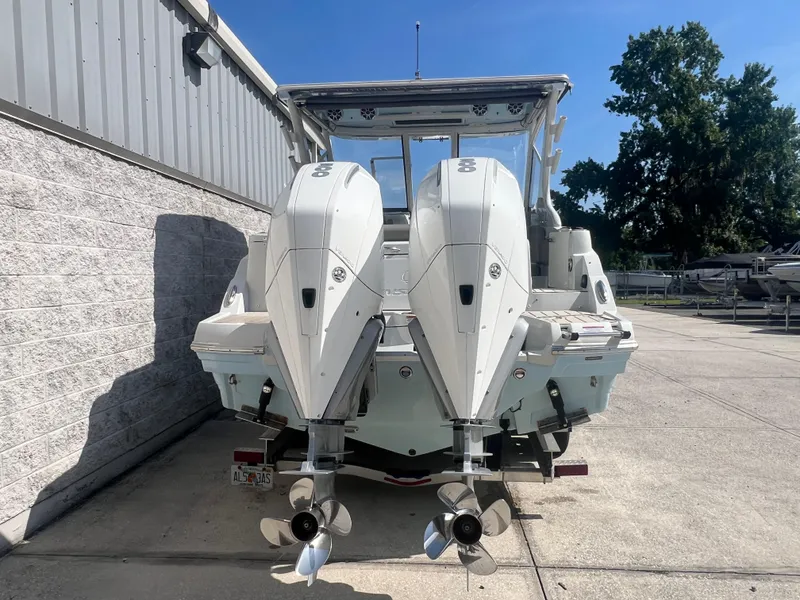 Slide: The Image of 2023 Finseeker 280 DC boat with dual outboard engines, parked outdoors. - 4