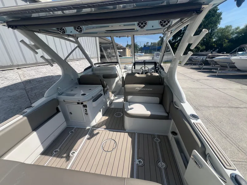 Slide: The Image of 2023 Finseeker 280 DC boat interior with seating and helm, docked outdoors. - 6