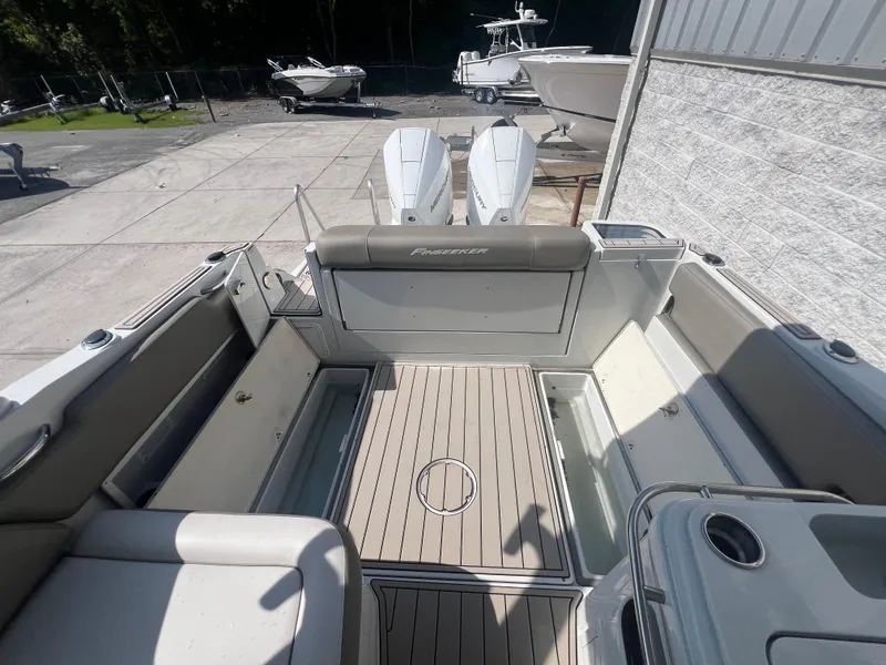 Slide: The Image of 2023 Finseeker 280 DC boat interior with dual engines, spacious deck, and seating. - 8