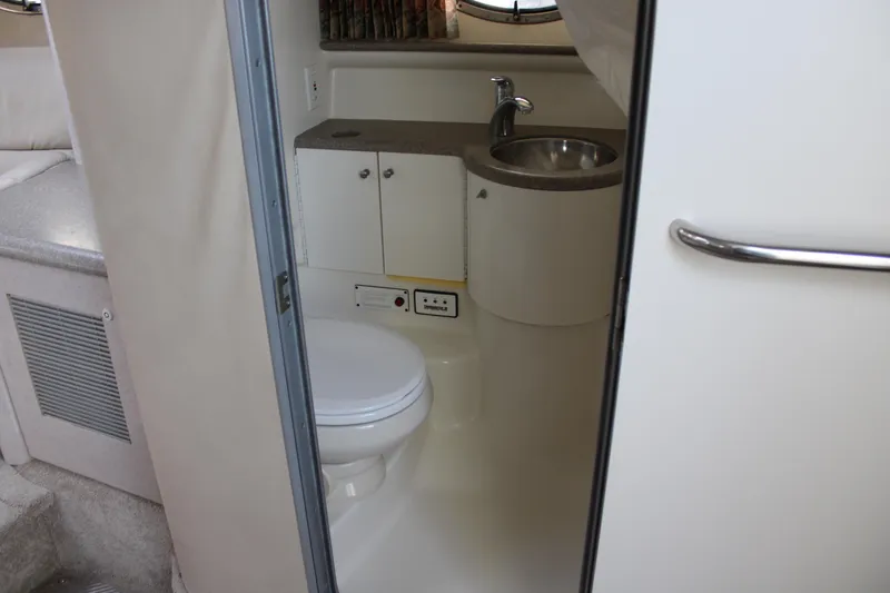 Slide: The Image of 1999 Formula 400 Super Sport boat bathroom with toilet, sink, and storage cabinets. - 39