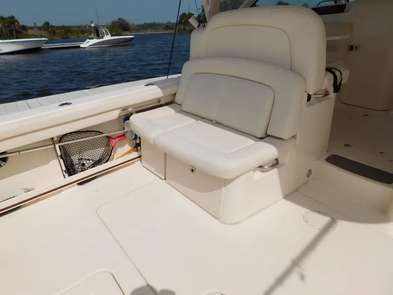 Slide: The Image of 2018 Grady-White Freedom 375 boat interior with cushioned seating by the water. - 10