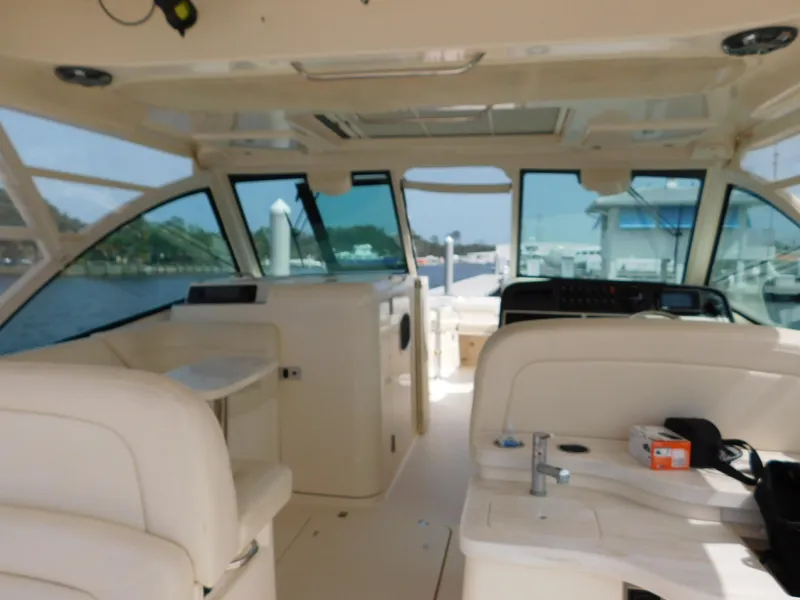 Slide: The Image of 2018 Grady-White Freedom 375 boat interior with seating and helm, docked at marina. - 27