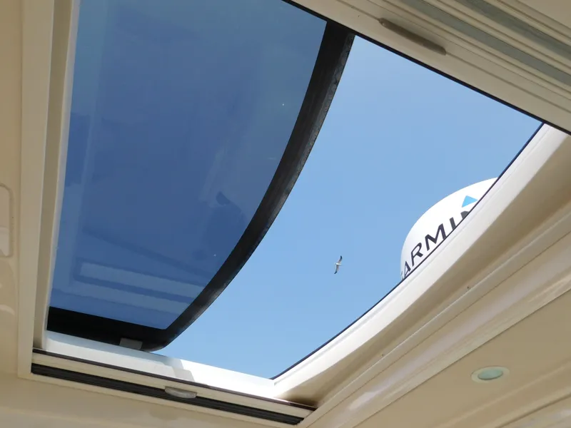 Slide: The Image of Open sunroof view from 2018 Grady-White Freedom 375 boat, showcasing clear blue sky. - 48