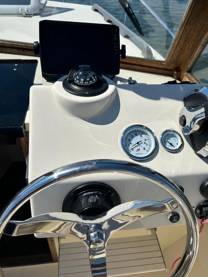 Slide: The Image of 2021 Seaway 21 Seafarer Cuddy helm with compass, gauges, and steering wheel. - 12