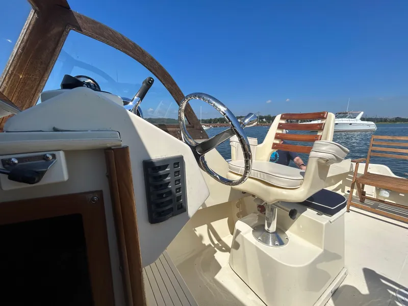 Slide: The Image of 2021 Seaway 21 Seafarer Cuddy boat helm with wooden accents and steering wheel. - 8