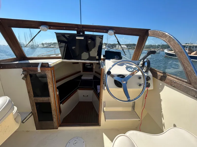 Slide: The Image of 2021 Seaway 21 Seafarer Cuddy interior with steering wheel and cabin view. - 9