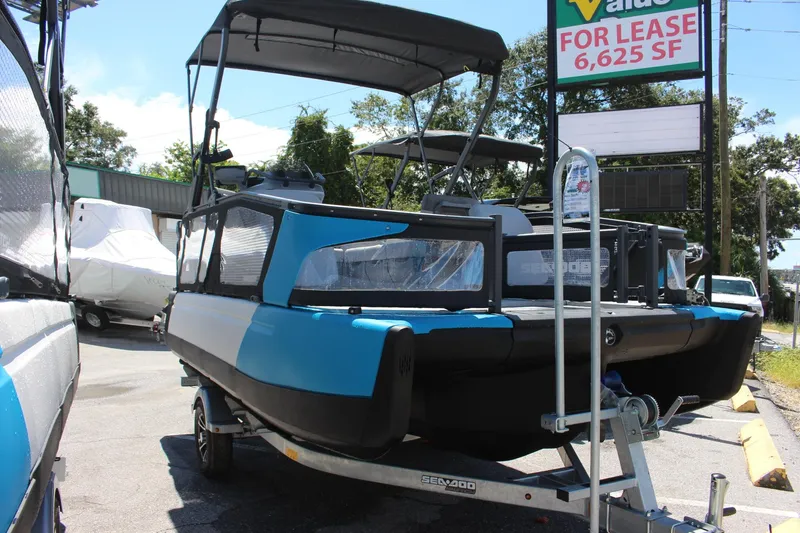 Slide: The Image of 2023 Sea-Doo Switch Sport 18 - 230 HP on trailer, blue and black, outdoor display. - 10