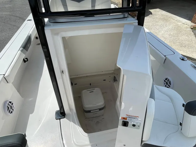 Slide: The Image of 2024 Robalo 226 Cayman boat interior with a portable toilet. - 6