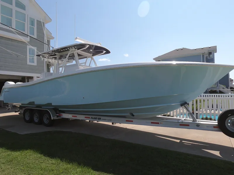 Slide: The Image of 2019 Invincible 39 CC boat on trailer, parked near residential homes. - 1