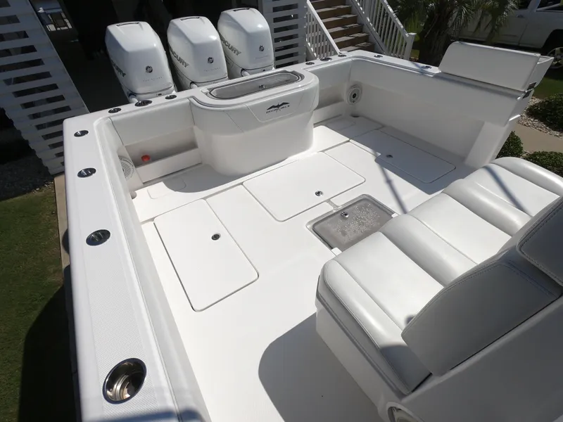 Slide: The Image of 2019 Invincible 39 CC boat deck with seating and triple outboard engines. - 15