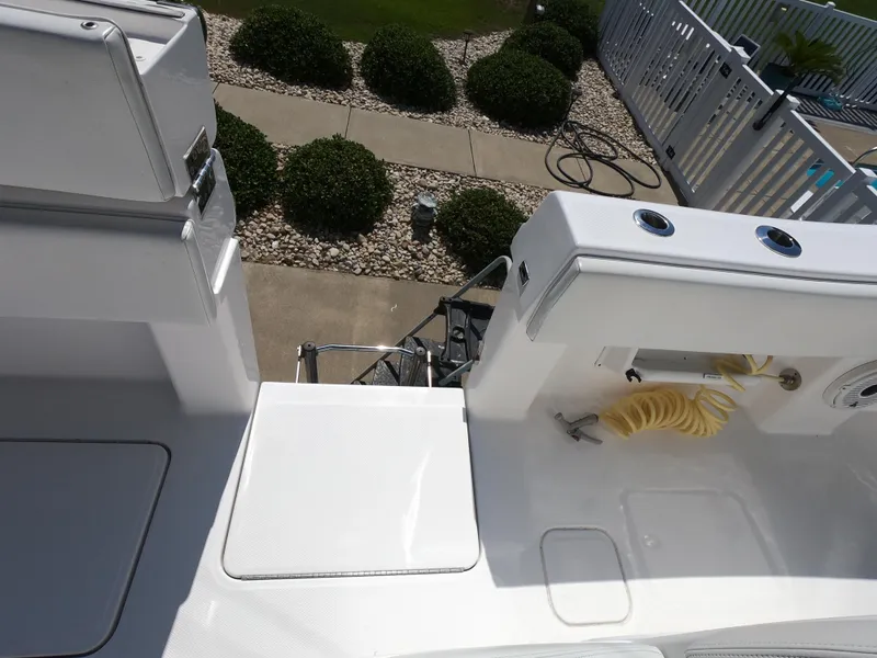 Slide: The Image of 2019 Invincible 39 CC boat deck with seating and hose, near landscaped garden. - 17