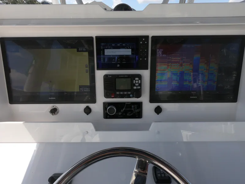 Slide: The Image of Control panel of 2019 Invincible 39 CC boat with navigation screens and steering wheel. - 20