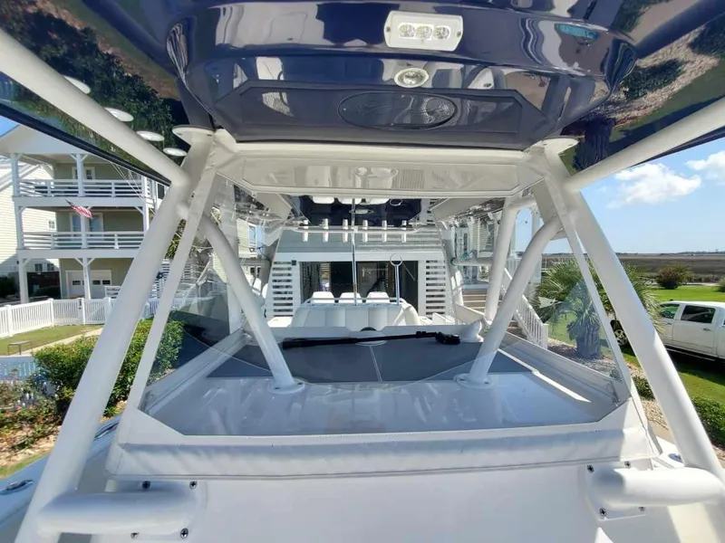 Slide: The Image of 2019 Invincible 39 CC boat with sleek design, docked near coastal homes. - 24