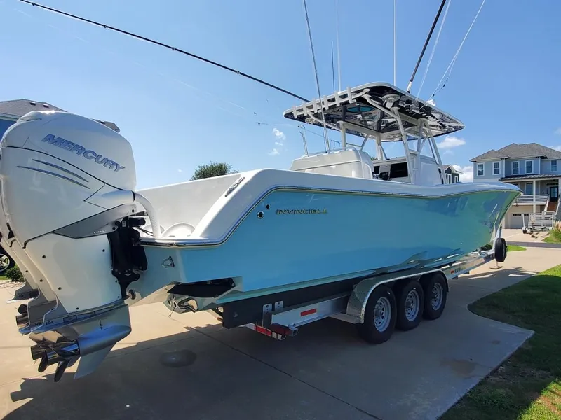 Slide: The Image of 2019 Invincible 39 CC boat with Mercury engine on a trailer in a driveway. - 31