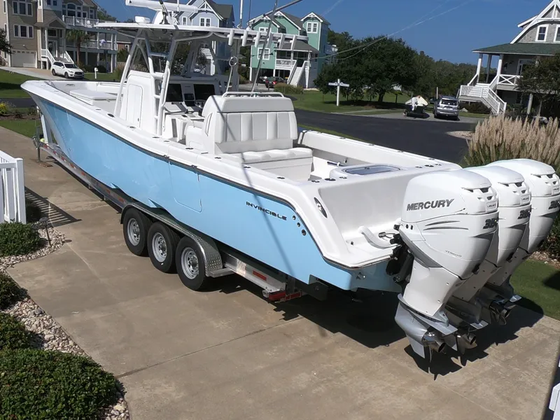 Slide: The Image of 2019 Invincible 39 CC boat with triple Mercury engines on a trailer. - 4